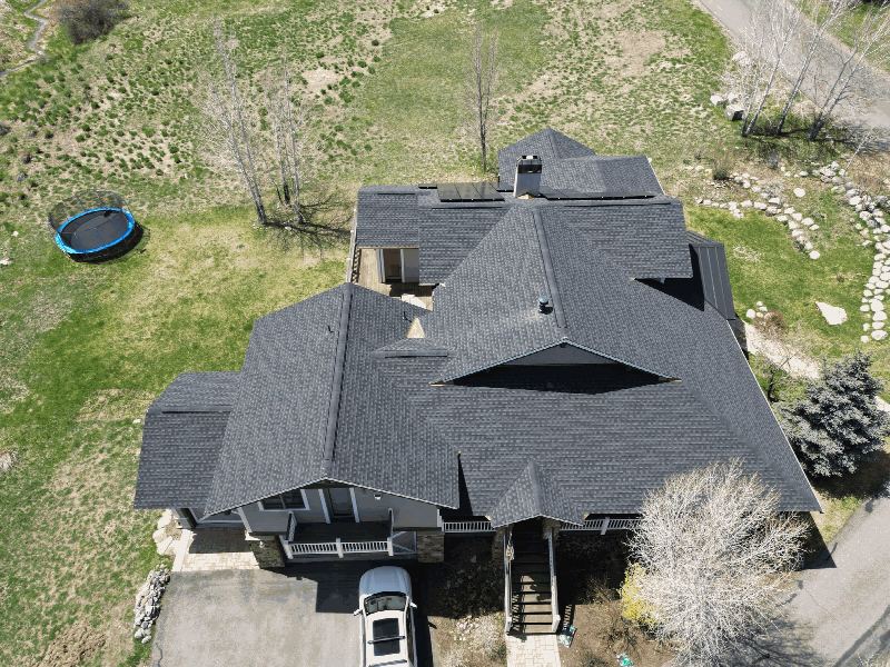 Aerial view of a large asphalt shingle roof being assessed for repair or replacement