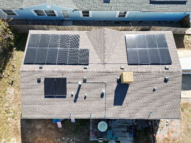 Aerial view of a completed residential roof with a rooftop solar array